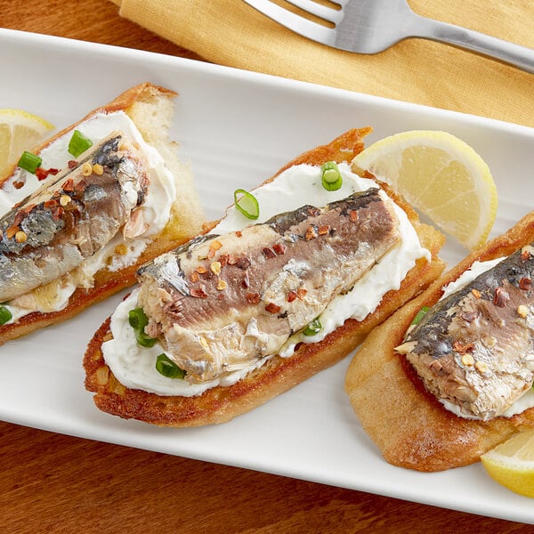 A plate of food with sandwiches and a lemon wedge.