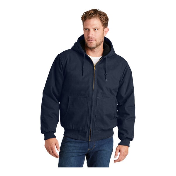 A man wearing a navy CornerStone hooded work jacket with a zipper.