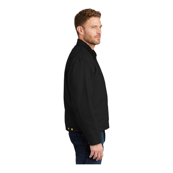 A man wearing a CornerStone black work jacket with a corduroy collar.