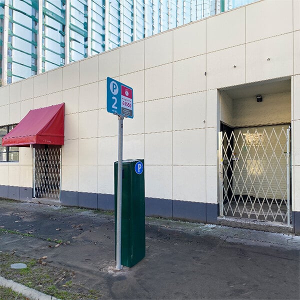 An Illinois Engineered Products heavy-duty galvanized steel folding security door gate in front of a building.