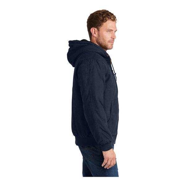 A person wearing a CornerStone navy work jacket with a hood.