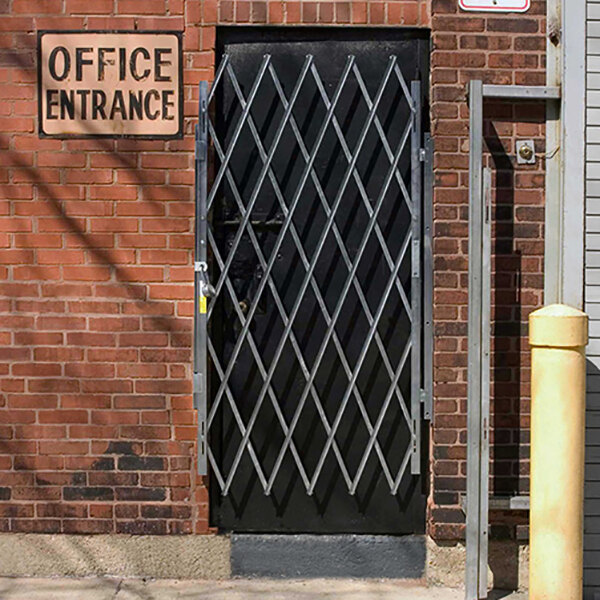 A metal Illinois Engineered Products folding security gate with a door handle.