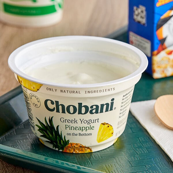 A white Chobani yogurt container with a blurry green and white label.