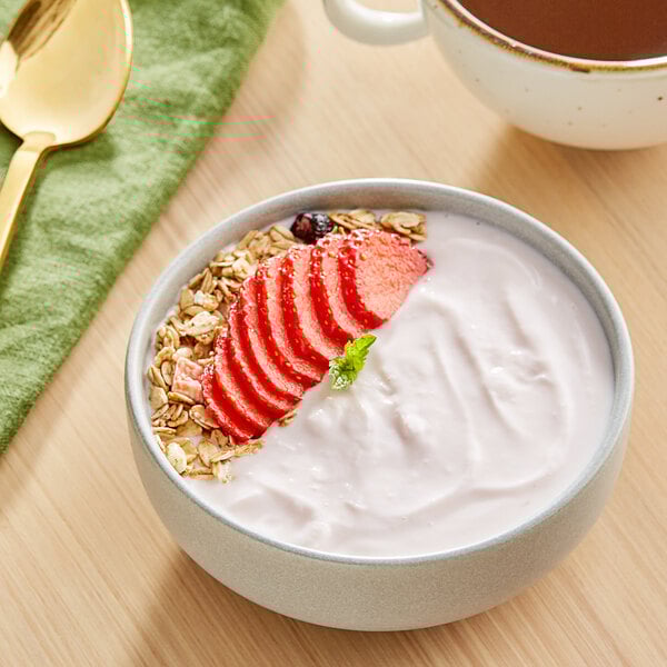 A bowl of Chobani strawberry Greek yogurt with strawberry slices and oat flakes.