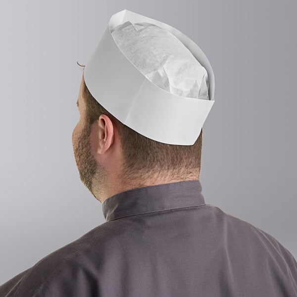 A man wearing a white Choice adjustable disposable chef hat.