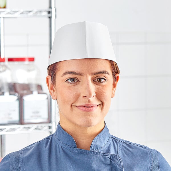 A woman wearing a white Choice adjustable disposable chef hat.