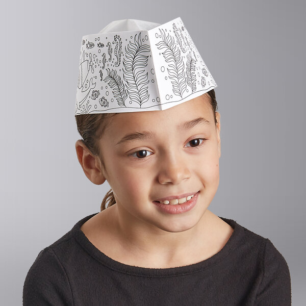 A little girl wearing a white Choice paper hat with black and white drawings of sea creatures.