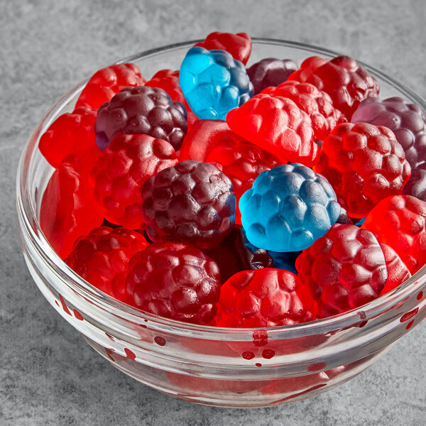 A bowl of Albanese gummy candies in red, blue, and black.