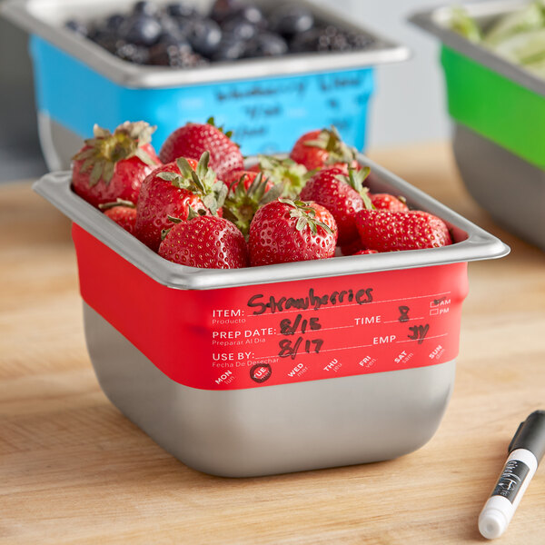 A Vigor stainless steel food pan band with a marker on a container of strawberries.