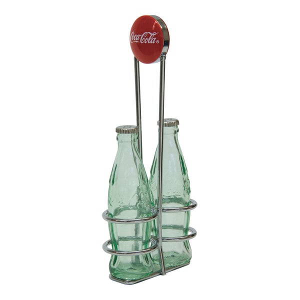 A chrome-plated caddy holding two green glass Coca-Cola bottle salt and pepper shakers.