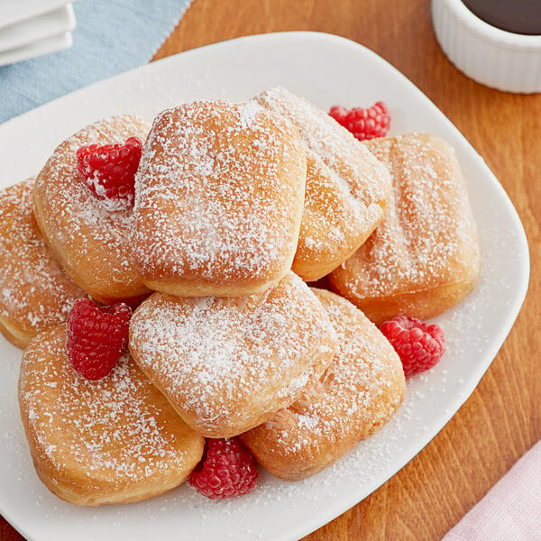 A plate of Brian's Fabulous FryBreads Plain New Orleans-Style Beignets with powdered sugar and raspberries.