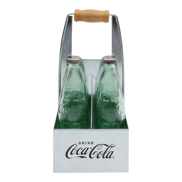 A Tablecraft green glass Coca-Cola bottle salt and pepper shaker set in a galvanized steel carrier with wooden handle.