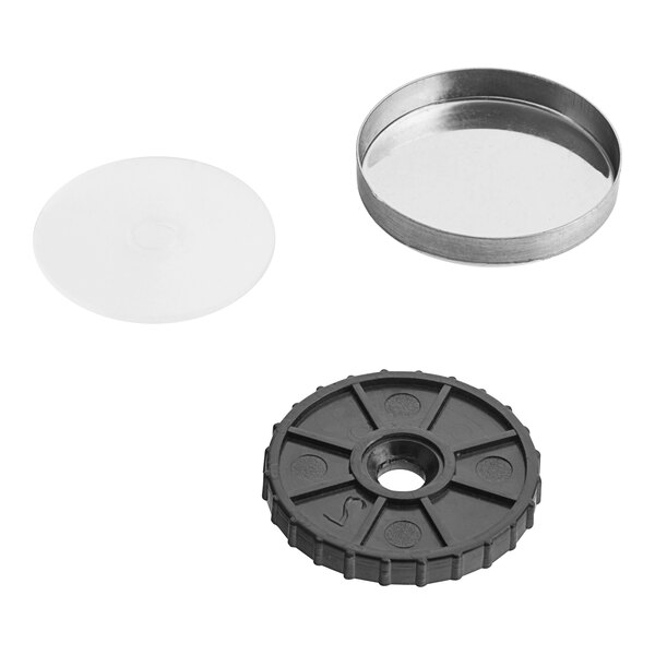 A metal plate with a round black plastic lid with a hole in the middle.