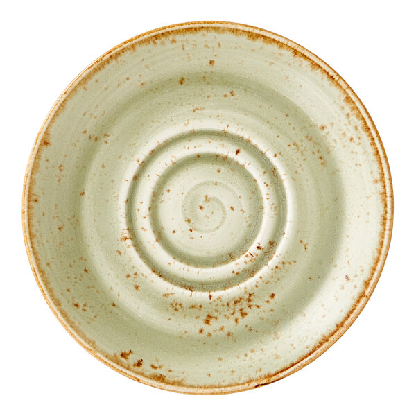 A green ceramic saucer with a rustic, speckled finish and concentric circular ridges.
