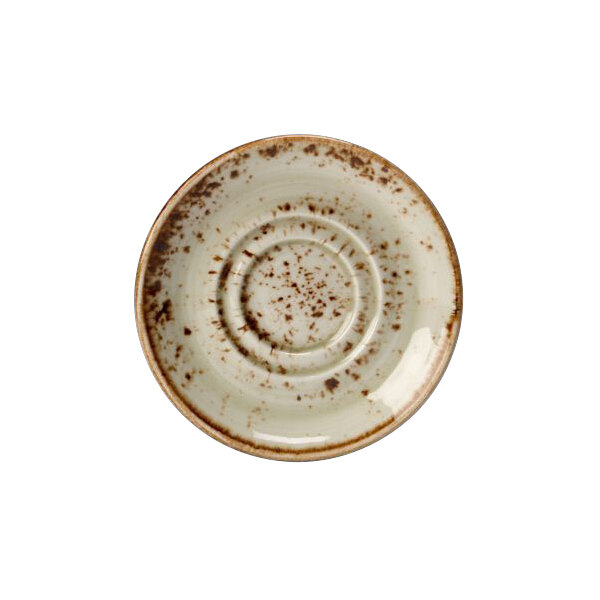 A white saucer with brown speckled spots.