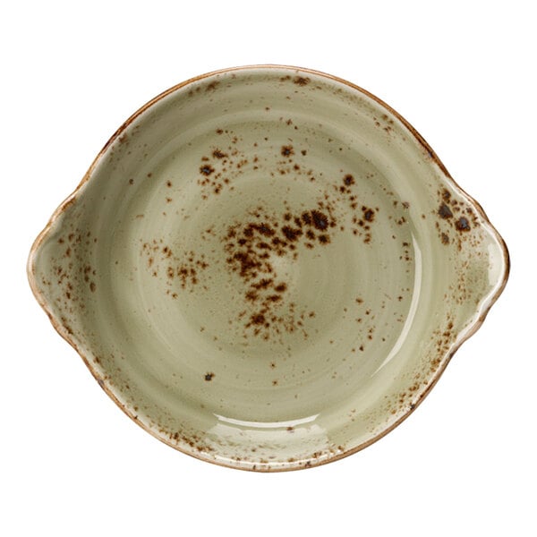 A green Steelite Performance Craft round eared dish with brown spots on a white surface.