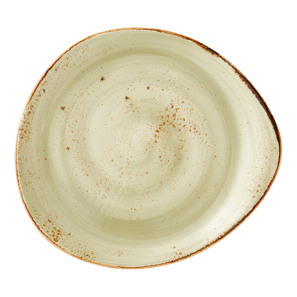 A large, irregularly shaped green ceramic plate with a speckled finish and rustic edges.
