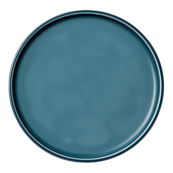 A close-up of a Schonwald Petrol Blue porcelain coupe plate with a rim.