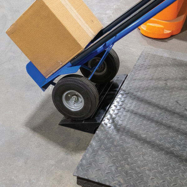 A hand truck with a box on a Vestil multi-purpose ramp.