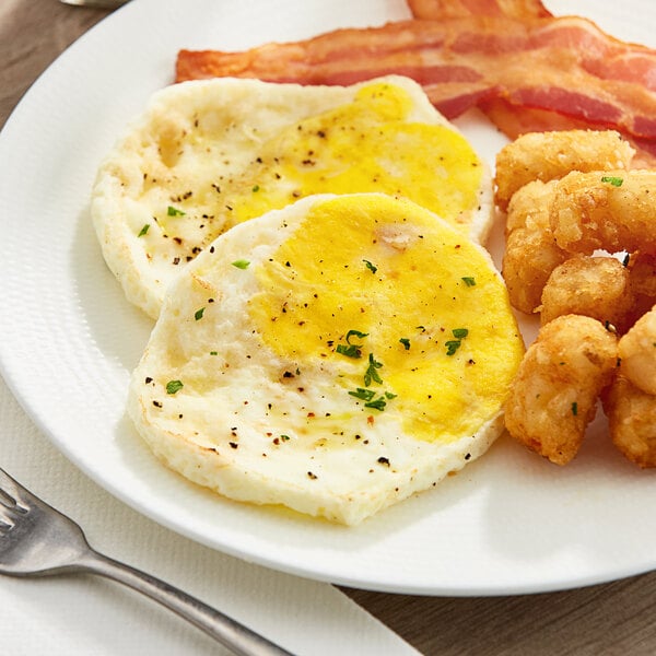 A plate of food with a Papetti's Homestyle fried egg patty, bacon, and shrimp with a fork on the side.