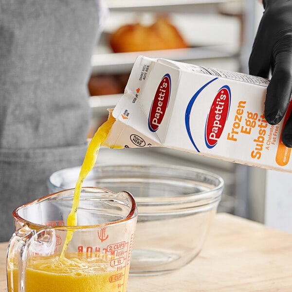 A yellow liquid being poured into a measuring cup.