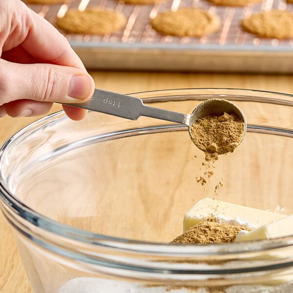 A person's hand holding a spoon with Hometown Provisions Ground Ginger.