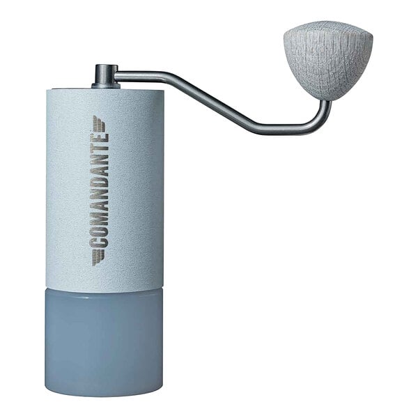 A close-up of a Comandante C40 coffee grinder with a white and grey handle.
