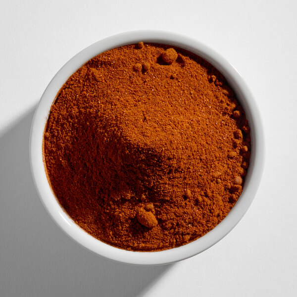 A white bowl filled with a reddish-brown powdered spice, viewed from above.