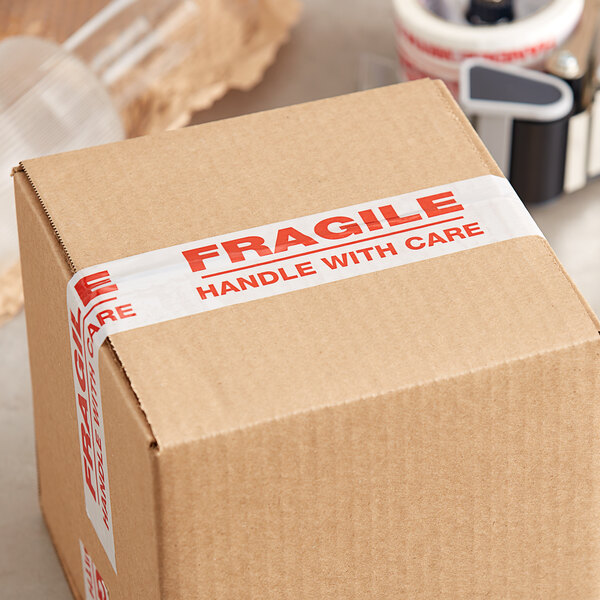 A cardboard box with Tape Logic white "Fragile / Handle With Care" tape on it.