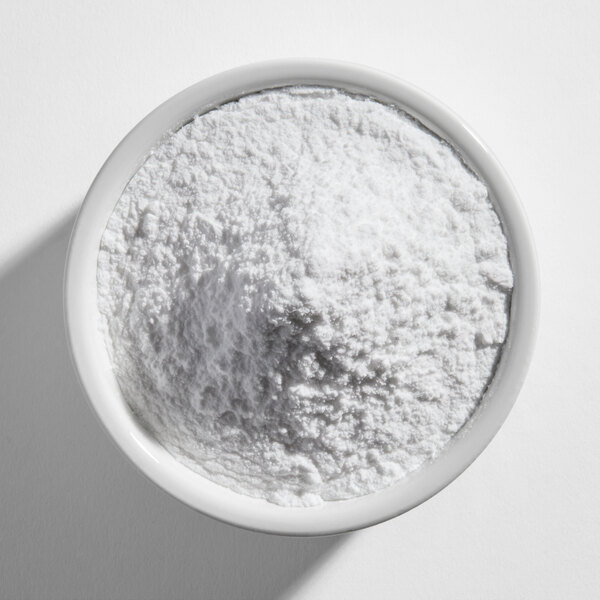 A white ceramic bowl filled with a fine white powder, viewed from above.