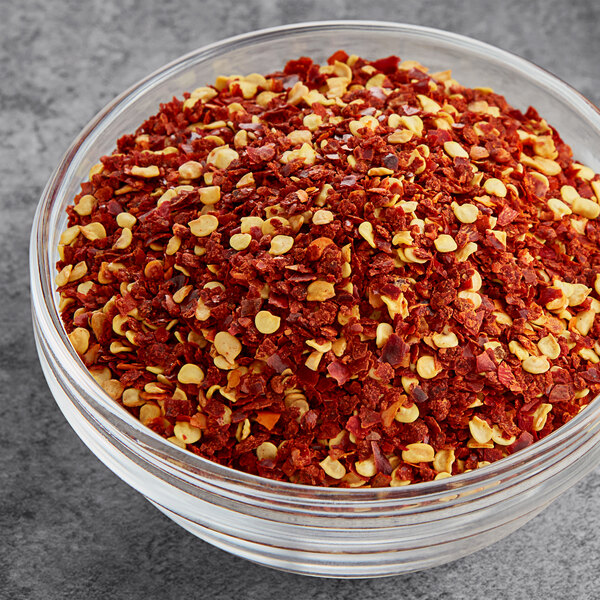 A bowl of Hometown Provisions crushed red pepper flakes on a table.