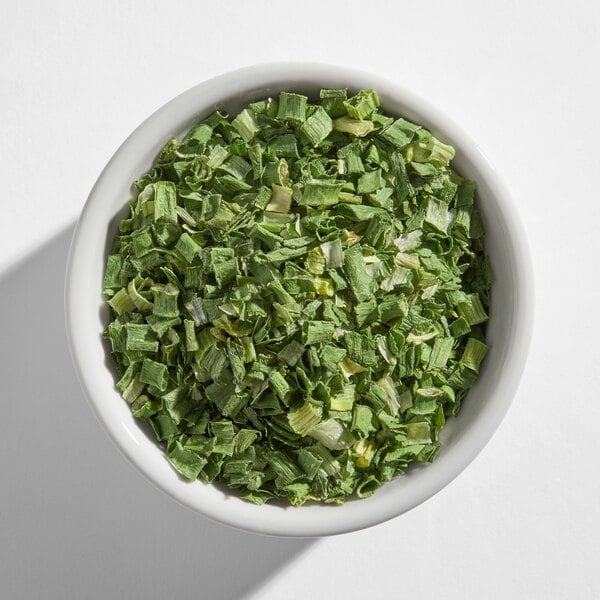 A small white bowl filled with dried chives.