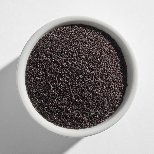 A white bowl filled with black poppy seeds.