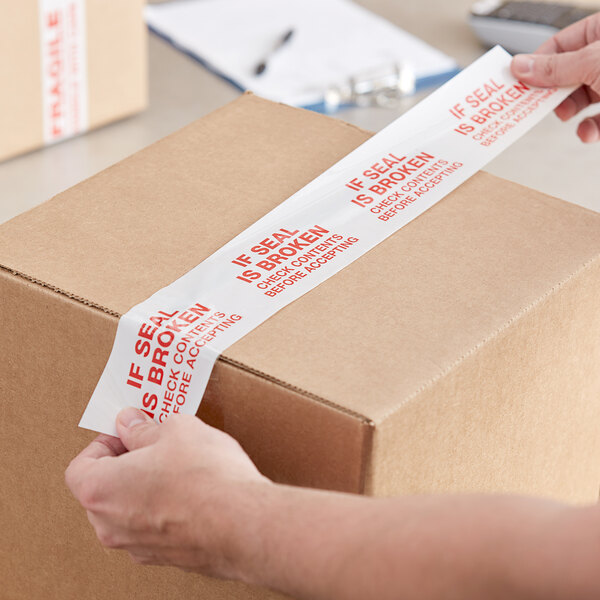 A person using Tape Logic carton sealer tape to seal a box.