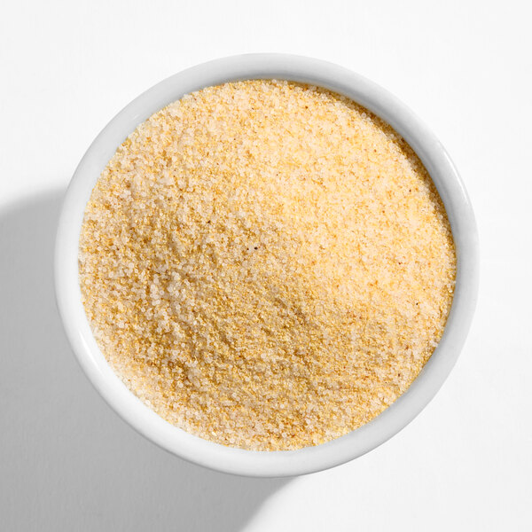 A white bowl filled with granulated garlic salt.