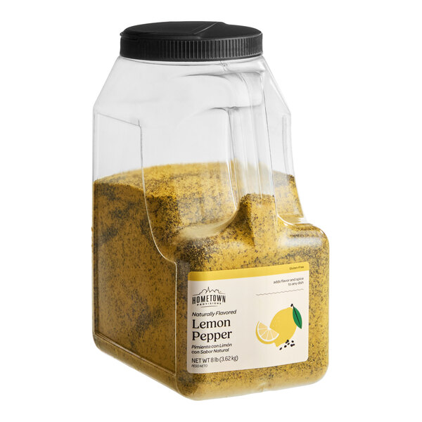 A large clear plastic container with a black lid, filled with a yellow and black speckled seasoning labeled as lemon pepper.