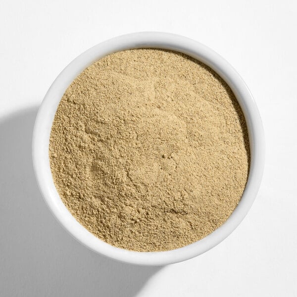 A white bowl filled with fine ground white pepper.