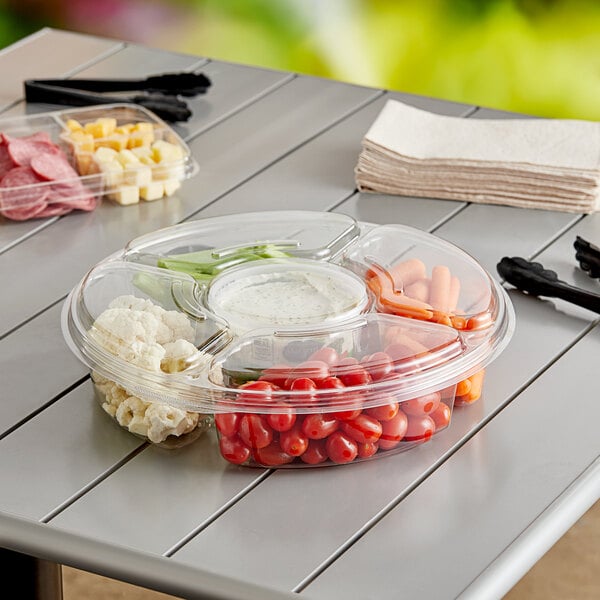 An Inline Plastics Essentials clear plastic 5-compartment round platter with a variety of food on it.