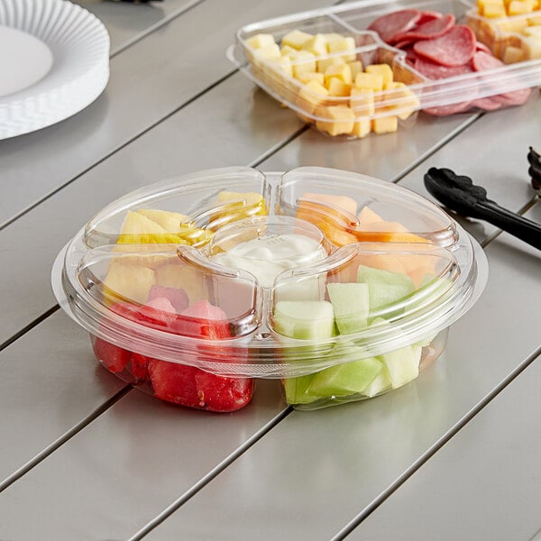 An Inline Plastics clear plastic 5-compartment tray with fruit in it on a table.
