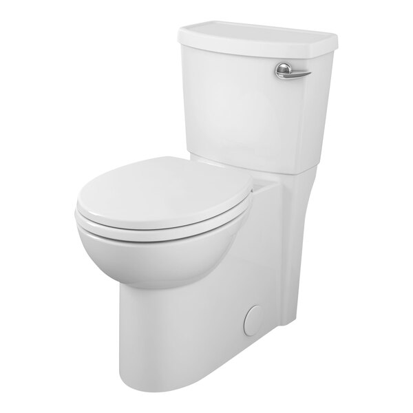 An American Standard white floor mount toilet with a silver handle and the seat down.