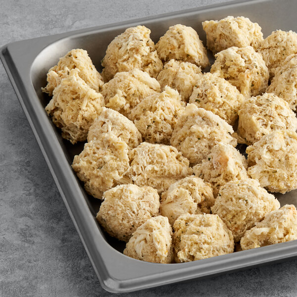 A gray tray filled with Kaptain's Ketch Mini Crab Cakes on a hotel buffet counter.
