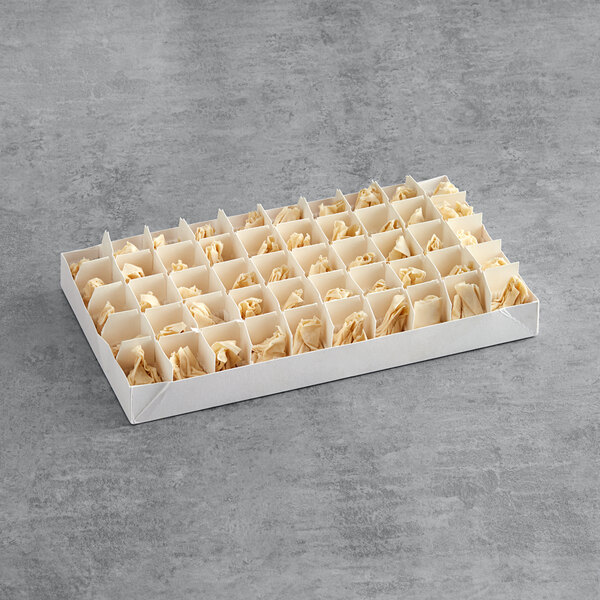 A white box of Simply Cuisine Poached Pear and Brie Fillo Purse hors d'oeuvres with small holes in it.