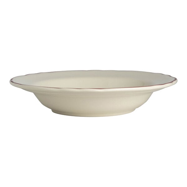 A white China bowl with a scalloped red rim.