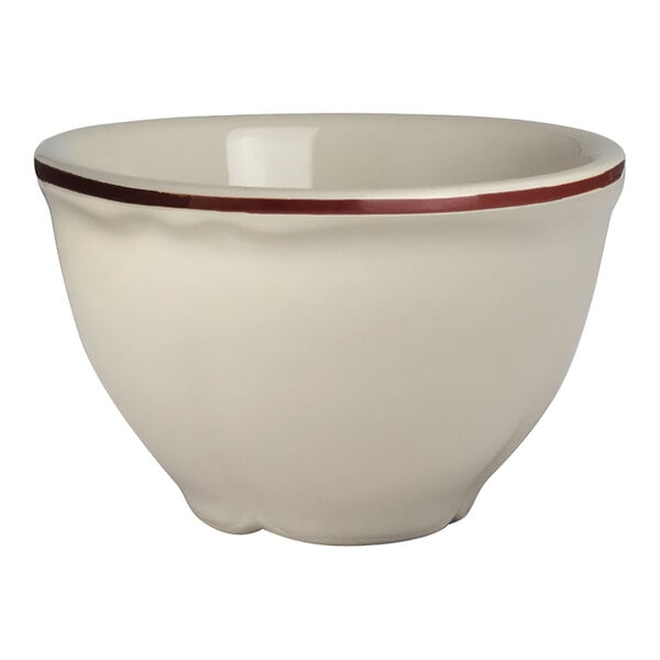 A white bouillon cup with a red scalloped rim.