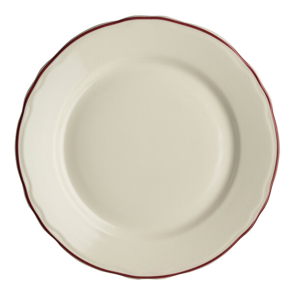 A close-up of a Homer Laughlin white china plate with red scalloped trim.