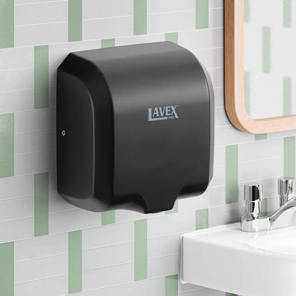 A black stainless steel automatic hand dryer with HEPA filtration mounted on a bathroom wall above a sink.
