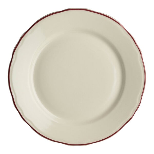 A close-up of a Homer Laughlin white china plate with maroon scalloped trim.