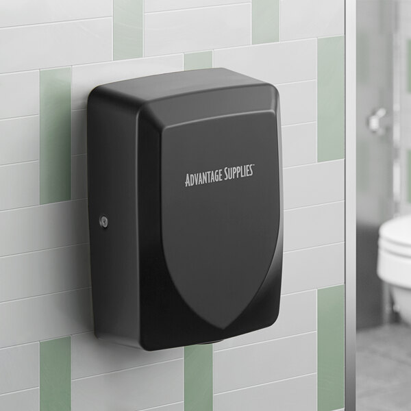 A black automatic hand dryer mounted on a tiled restroom wall.