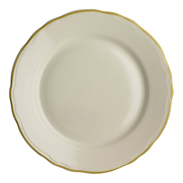 A close-up of a Homer Laughlin white china plate with scalloped edges and gold trim.