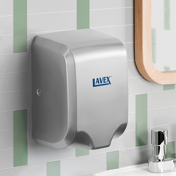 A stainless steel automatic hand dryer mounted on a bathroom wall.